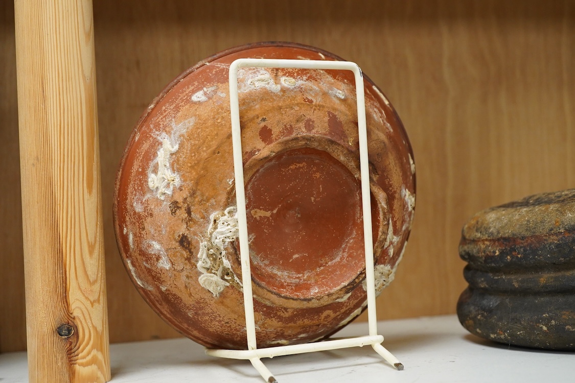 A Roman Samian ware bowl with provenance, allegedly from the Pan Rock shipwreck, together with an Iron Age Quern stone, largest 19cm in diameter